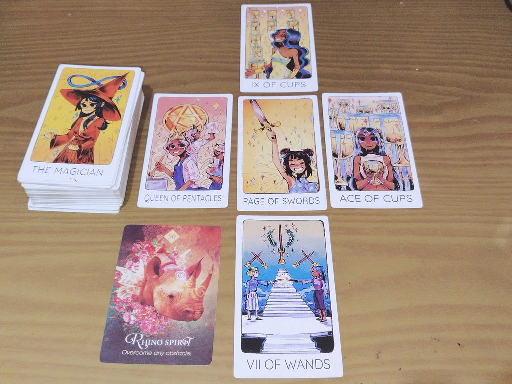 Pile #1: (1) Nine of Cups, (2) Page of Swords, (3) Queen of Pentacles & The Magician, (4) Ace of Cups, (5) Seven of Wands, (6) Rhino Spirit: “Outcome Any Obstacle”