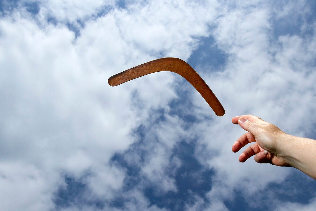 Photo of person tossing a boomerang through the air