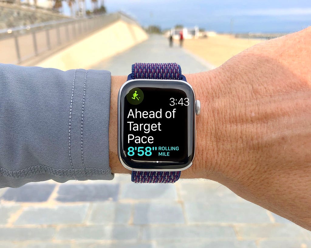 An Apple Watch being worn by a jogger telling them that they are ‘ahead of their target pace’
