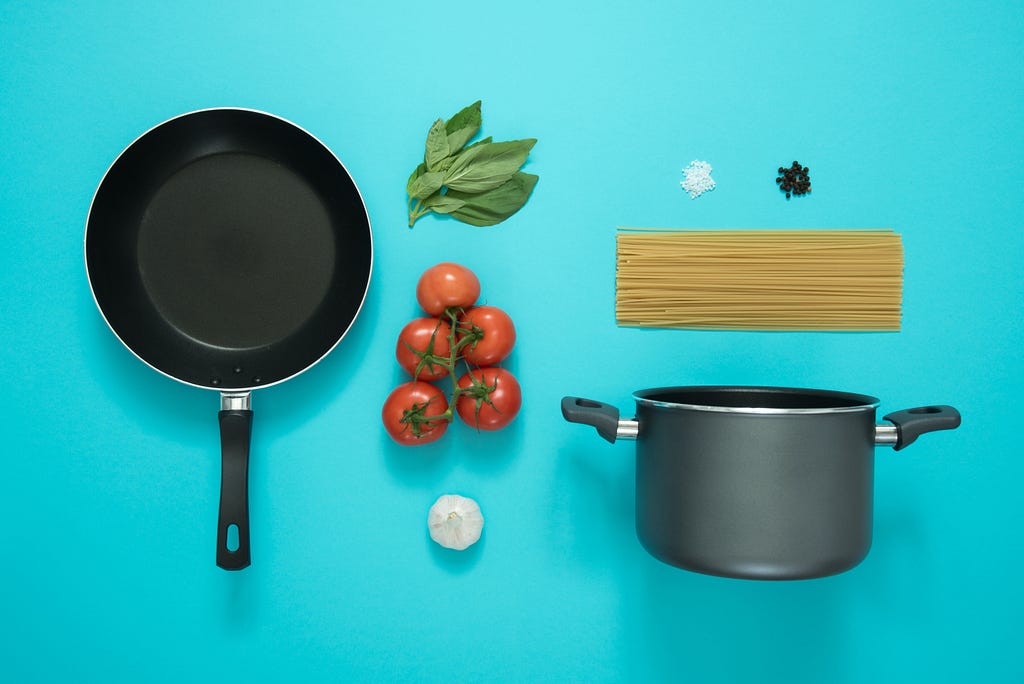 A pan, a pot, and food on a blue background