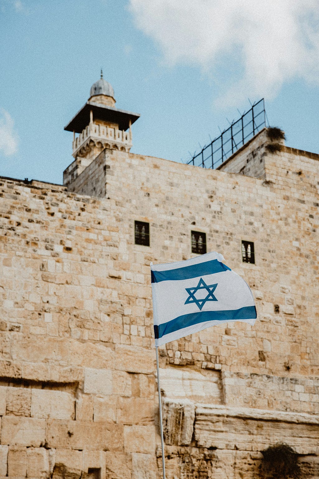 The flag of Israel waving near the city of Jerusalem.
