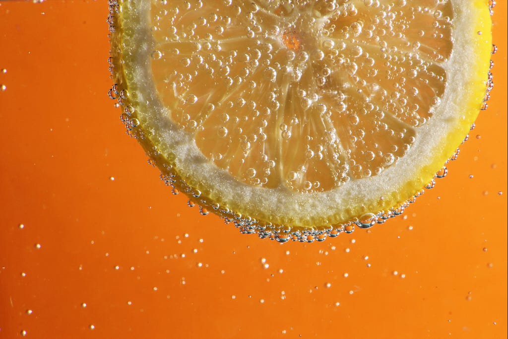 A slice of orange in a fizzy drink.