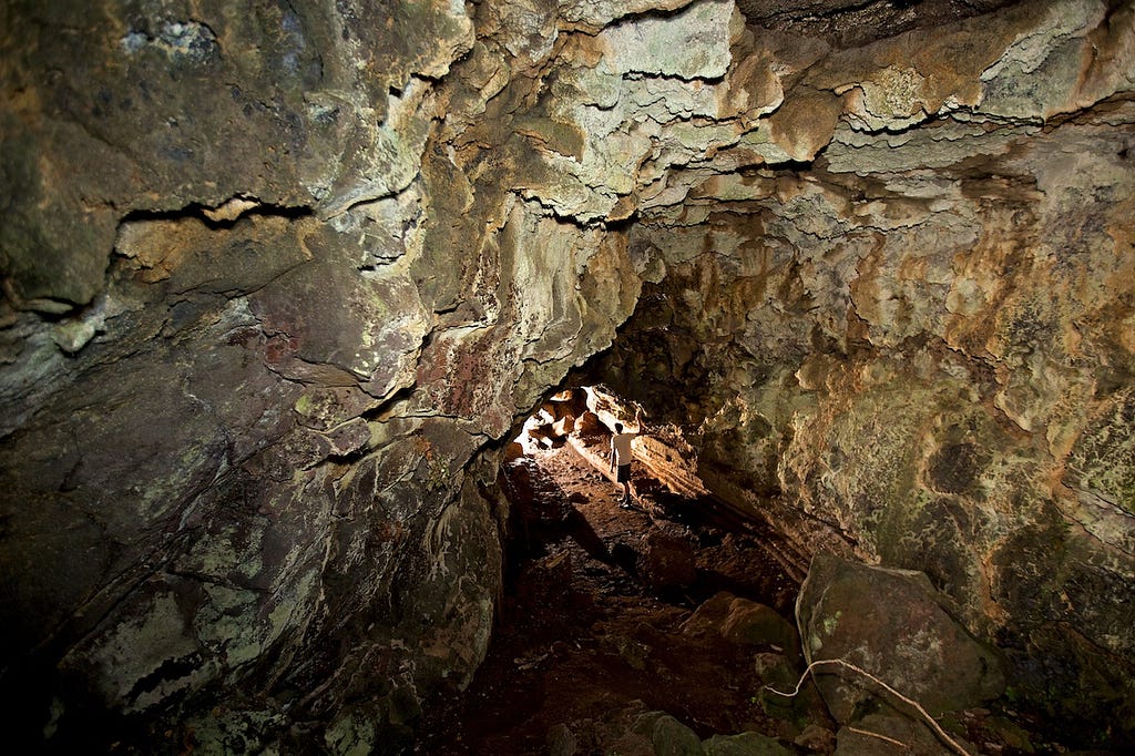 Photos Of The Galápagos Image: A lone traveller wearing dark shorts and a light t-shirt walks through a cave.