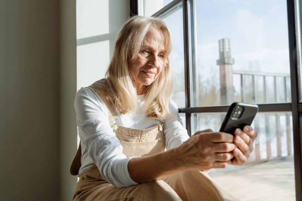 An elderly woman holding her phone with a call identified by CallApp