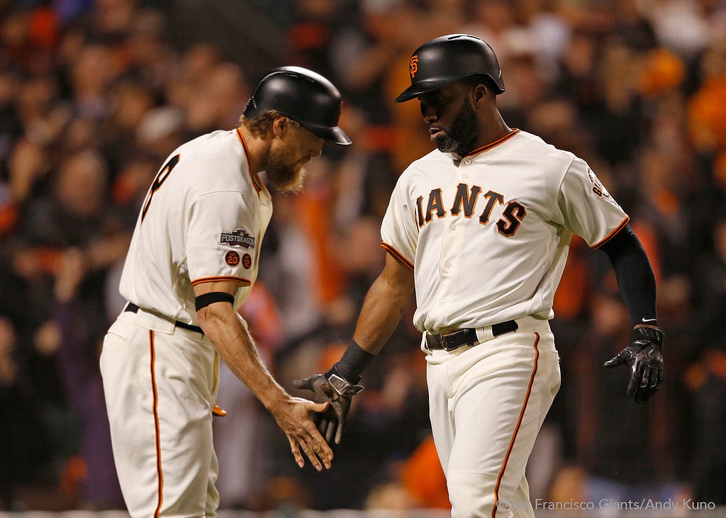 Hunter Pence high fives Denard Span after he scored on a single hit by Buster Posey in the third inning.