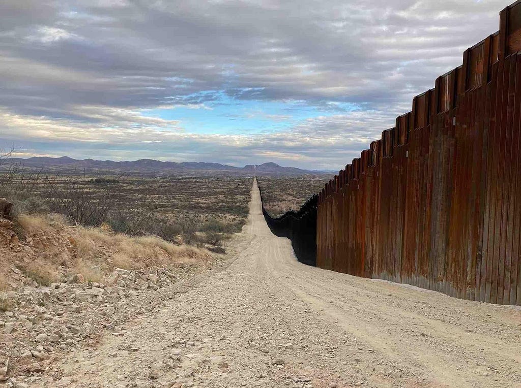 Border wall along El Camino Del Diablo, the Devil’s Highway, stretching away, desolately, into the distance.