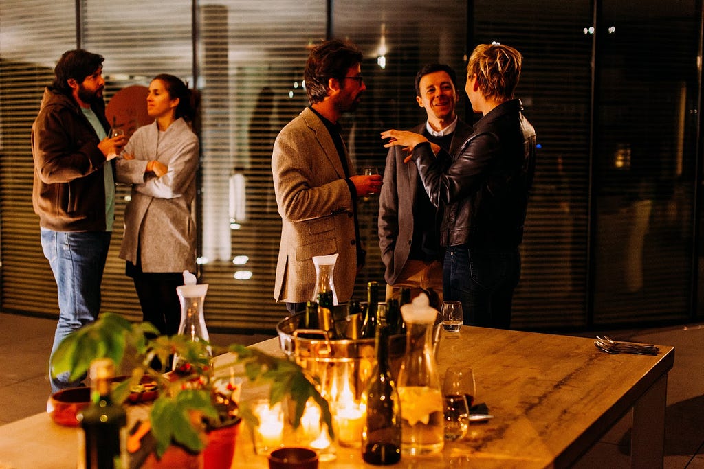 Three people having a conversation at a networking event.