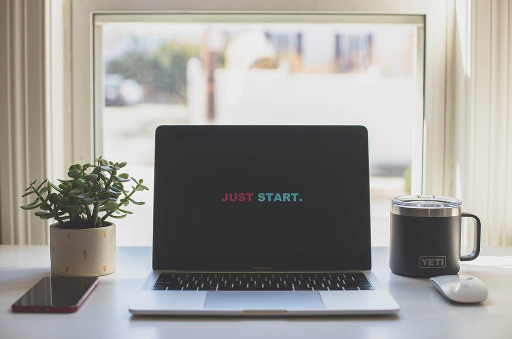 Laptop with a screen reading “Just Start”