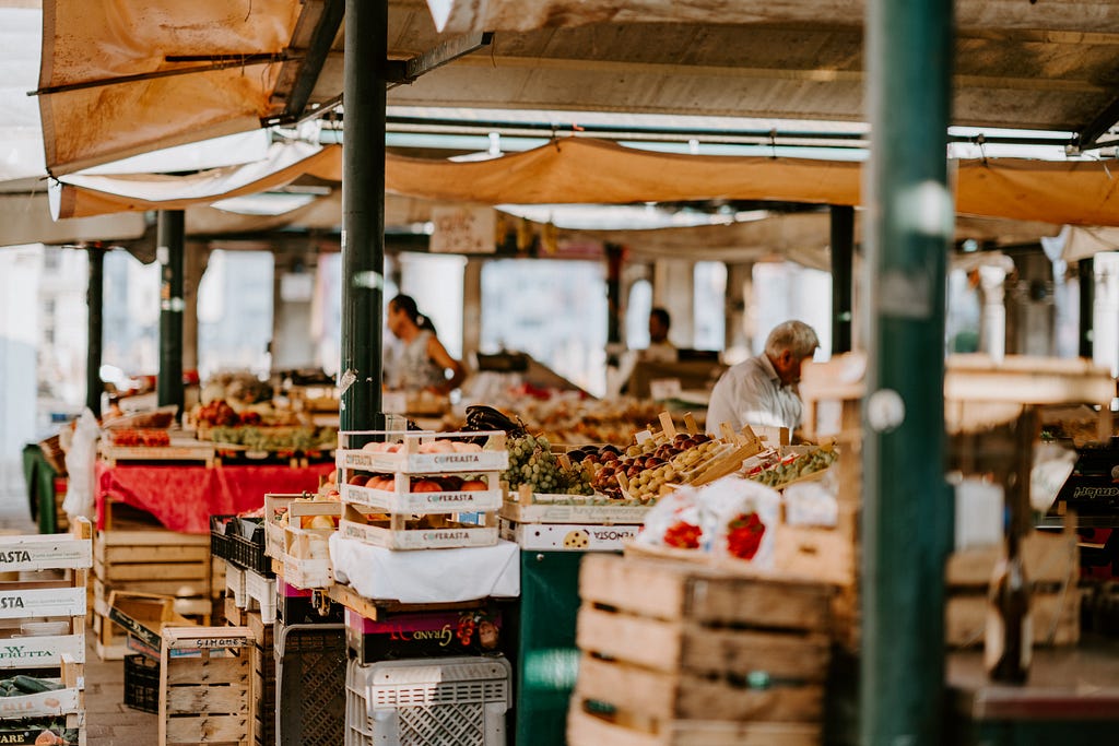 A picturesque market you dream about visiting on your next holiday abroad, with crates and crates of produce covered by canopies. You can just see the warmth radiating through the canopies and image.