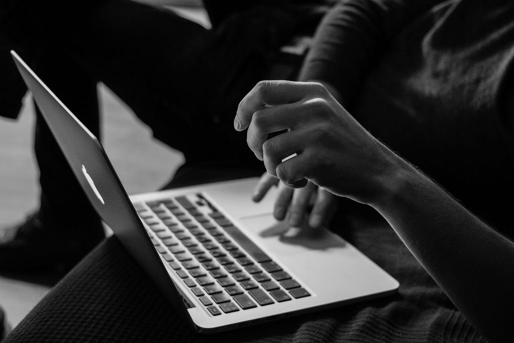 hands using laptop black and white photo