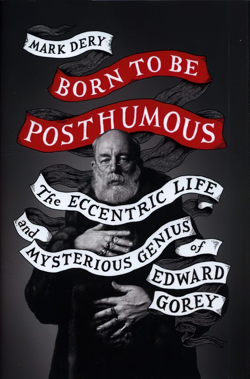 The book cover to Posthumous: The Eccentric Life and Mysterious Genius of Edward Gorey by Mark Dery. The photo is of a mock-serious looking Gorey looking at the camera. He wears one of infamous fur coats, before he gave up wearing them. His many rings are on display.