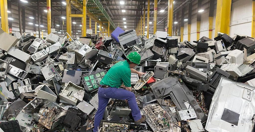 man in e-waste facility extract devices to destroy or recycle