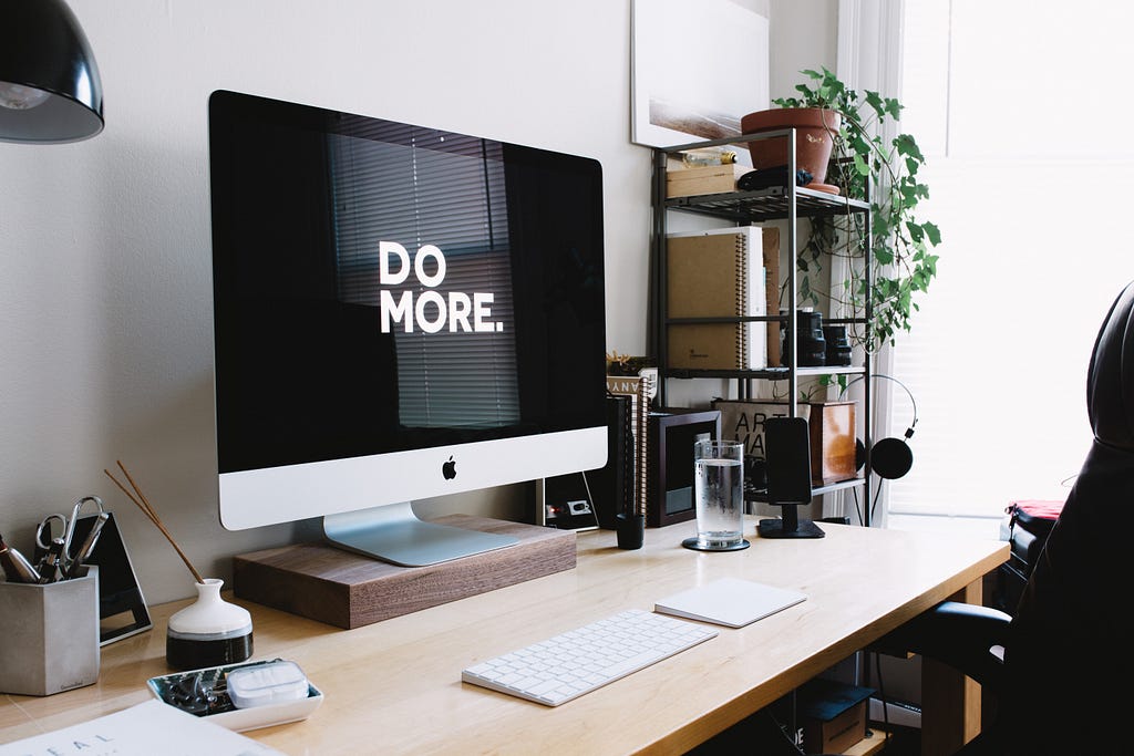 Workstation with the background of the monitor displaying “Do More” as a motivational phrase