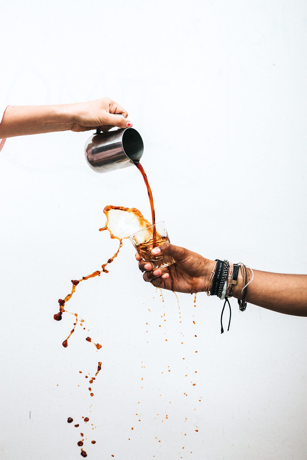 A photo of the world’s worst way to “hand off” a cup of hot coffee to another person.