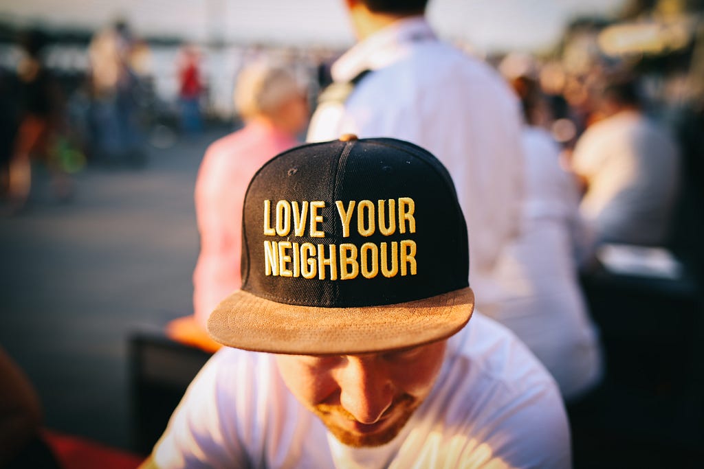 Man wearing cap that says ‘Love your neighbour’
