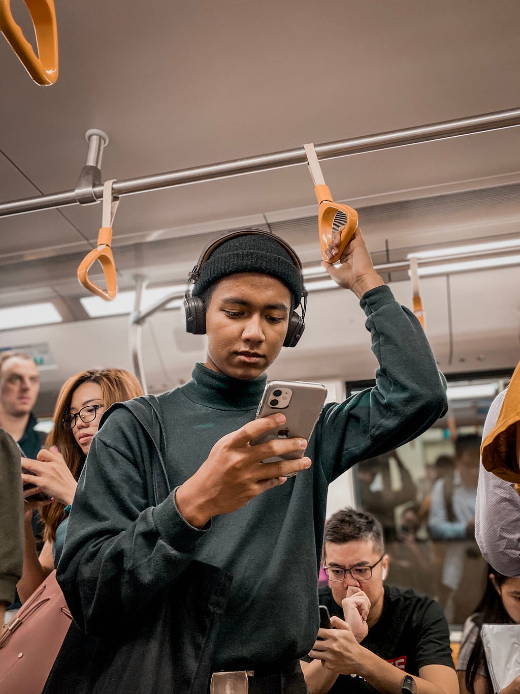 Man in metro looking at his phone.