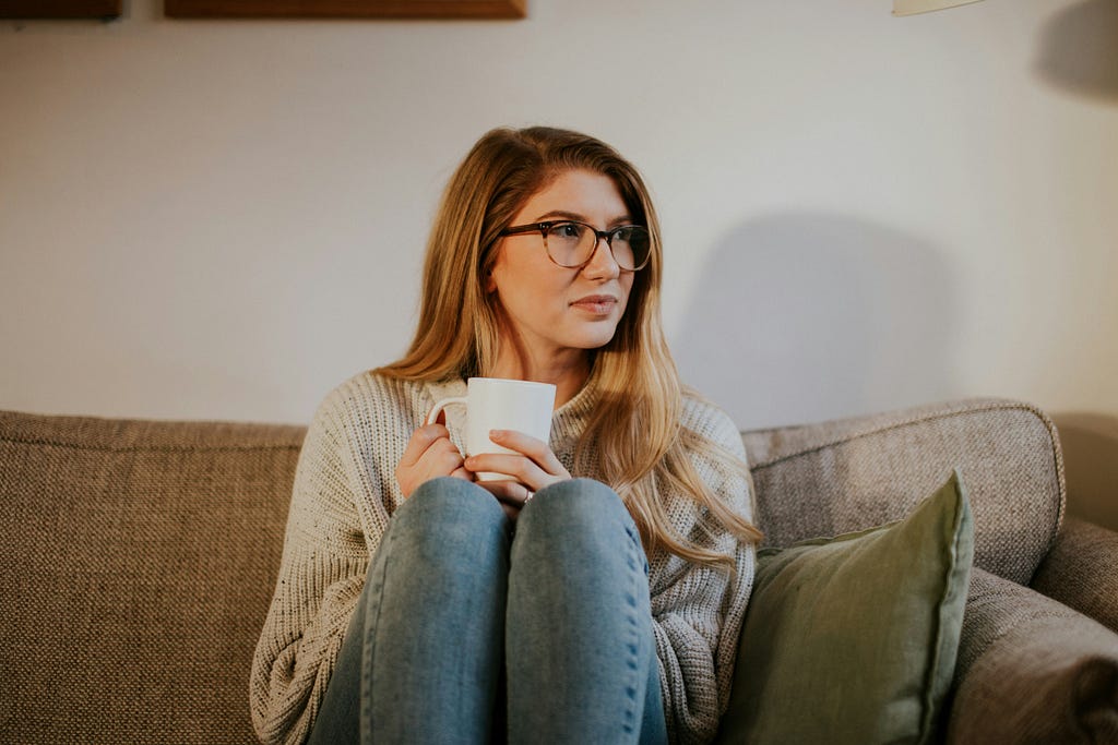 woman thinking with coffee in hand thinking about what to do when someone let her down.