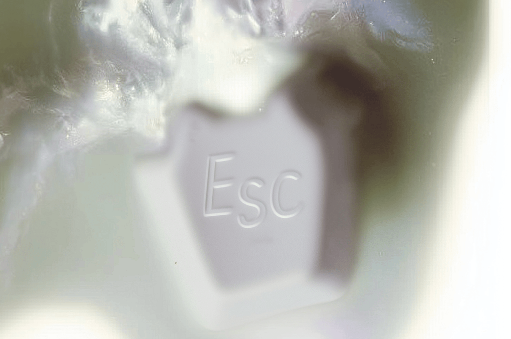An Escape keyboard button melting into the background
