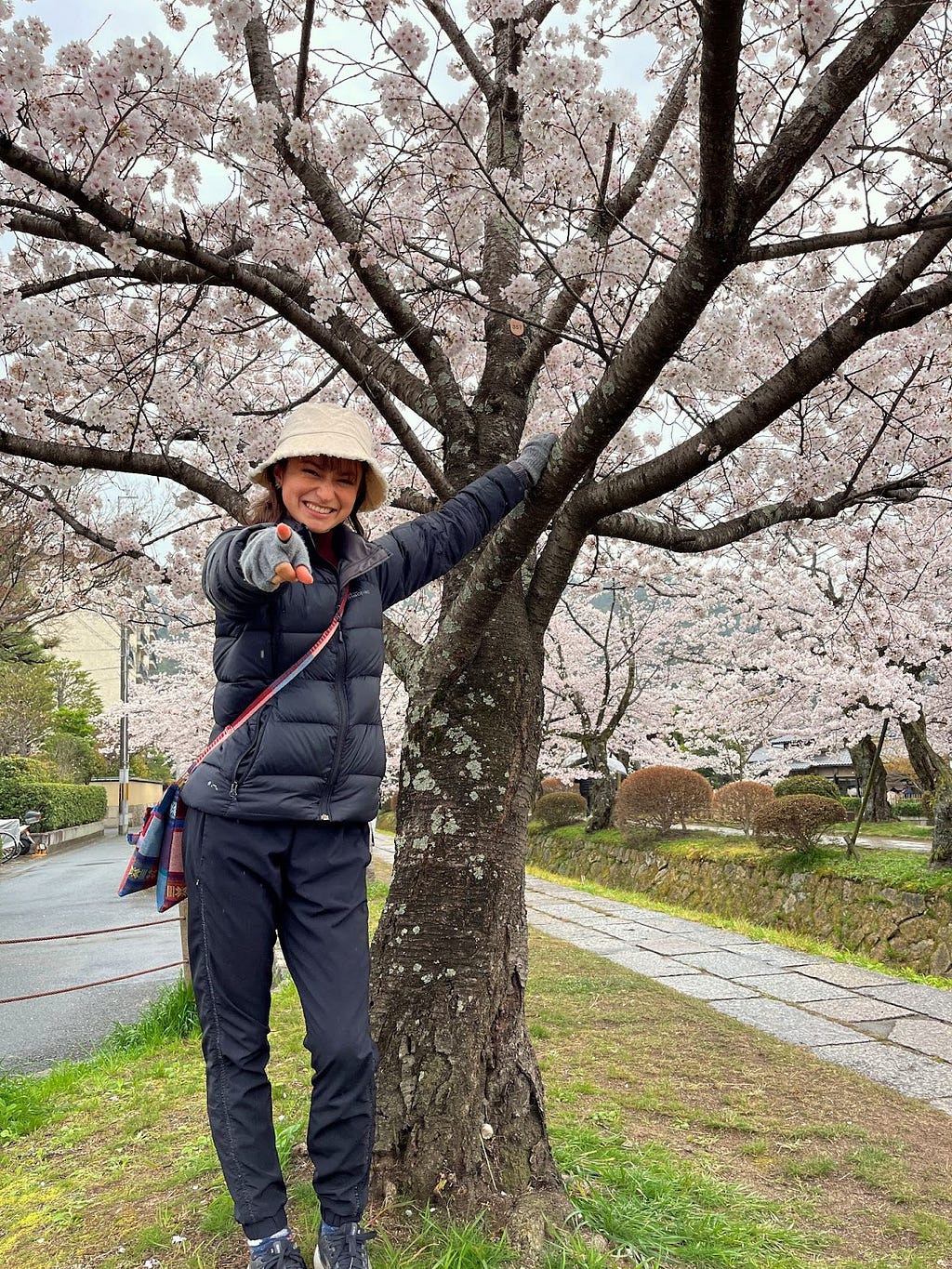 Woman standing next to cherry blossom tree