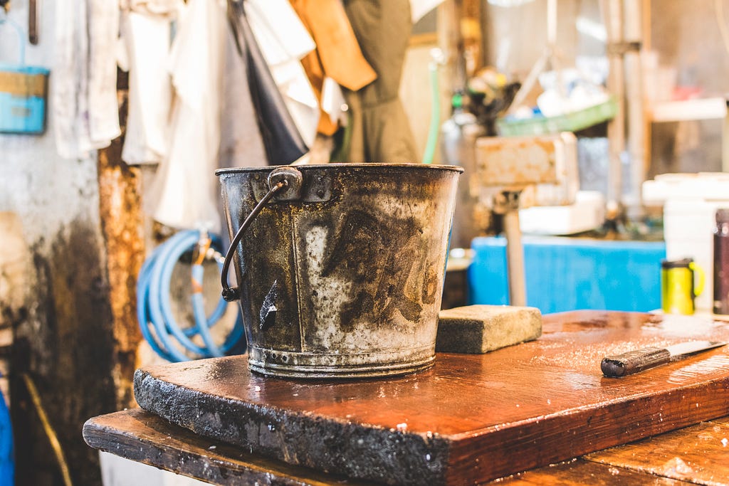 rusty bucket on wood slab in art studio