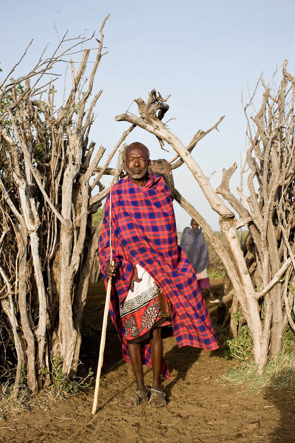 A Maasai elder wears a tartan wool shuka to ward off the early morning chill.