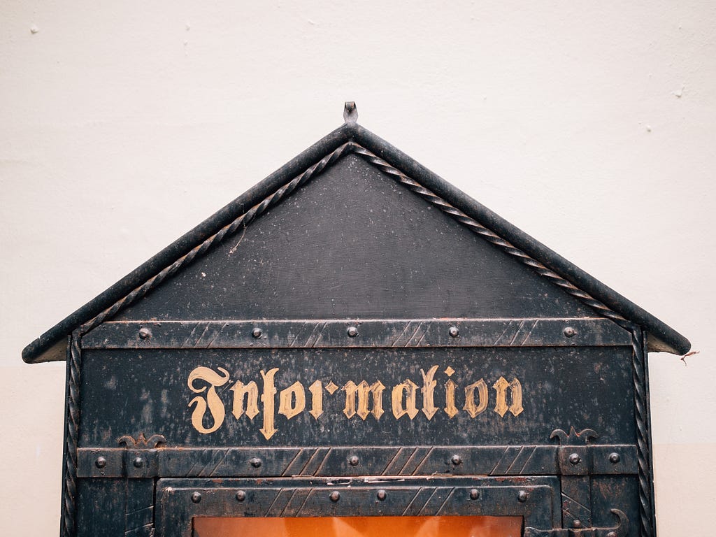 pic has a sign on a building that says “Information”