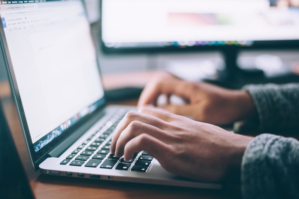 Man’s hands typing on a laptop