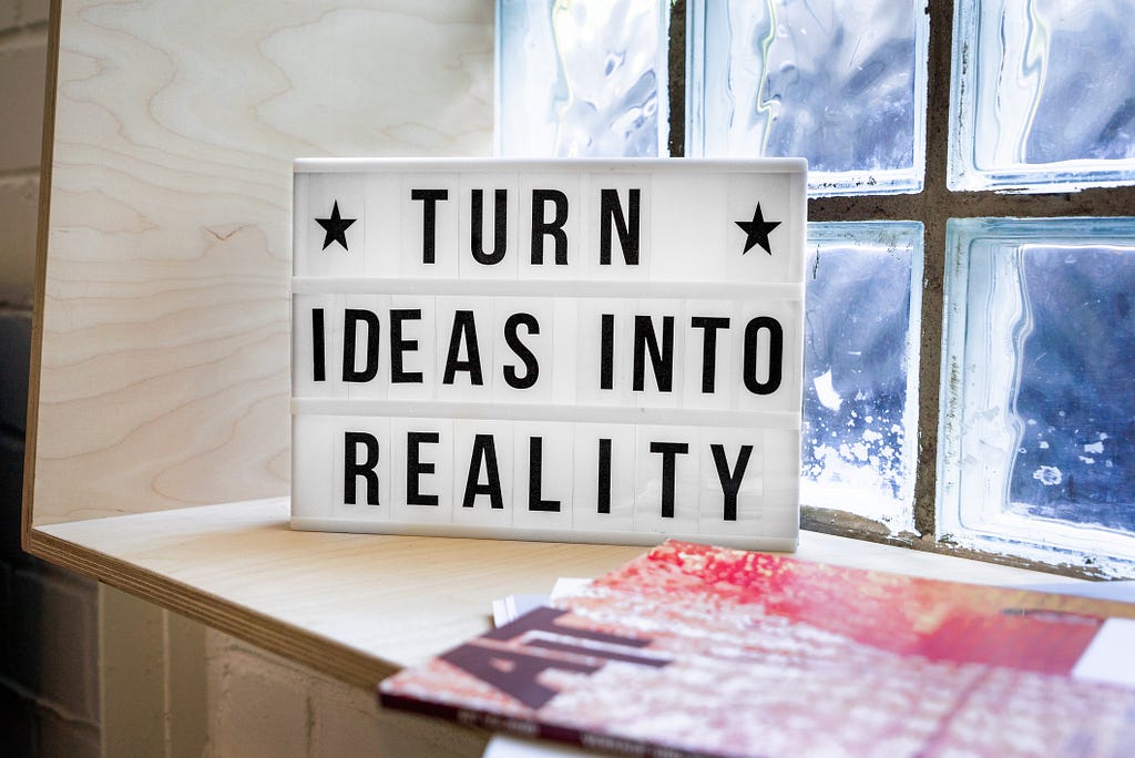 A photo of a letterboard on a window seat “Turn ideas into reality.” Tech start up