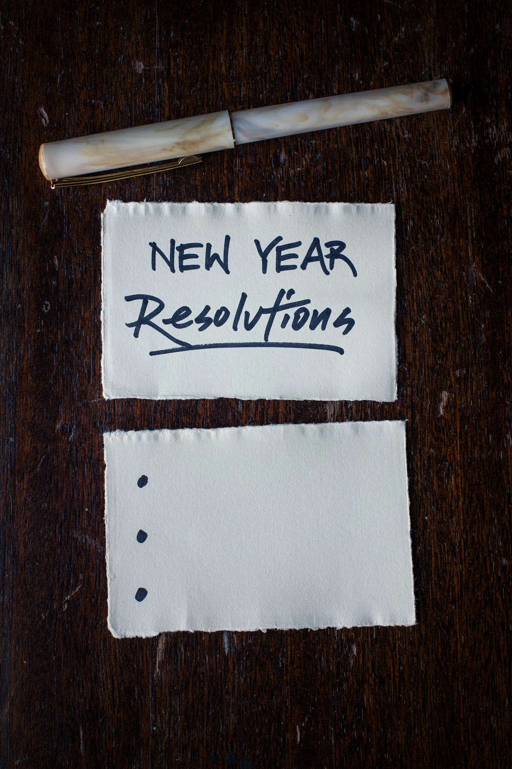 A picture of a pad and paper. The paper has a title of New Year`s resolutions
