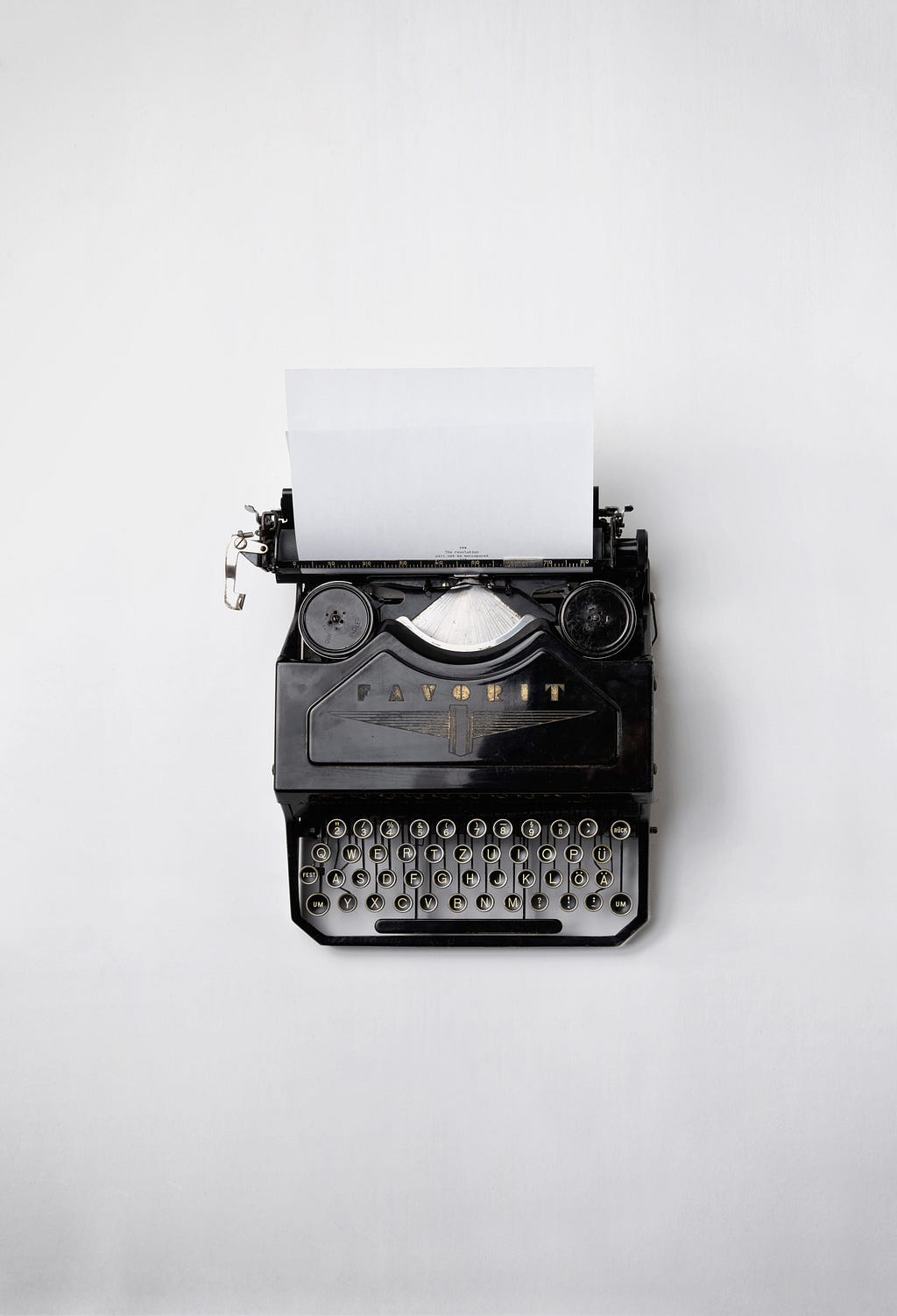An antigue typewriter with a blank sheet of paper