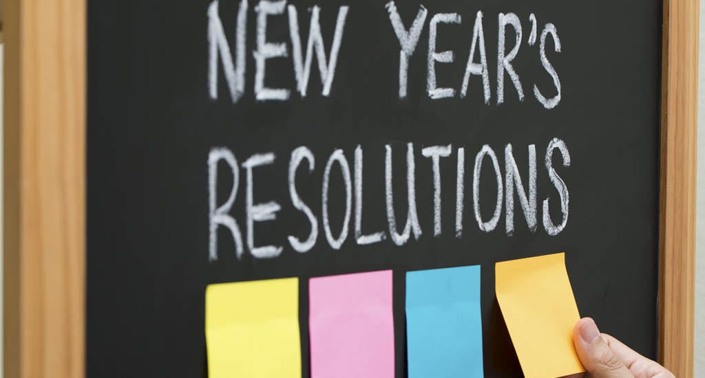 New year resolutions with sticky notes on blackboard