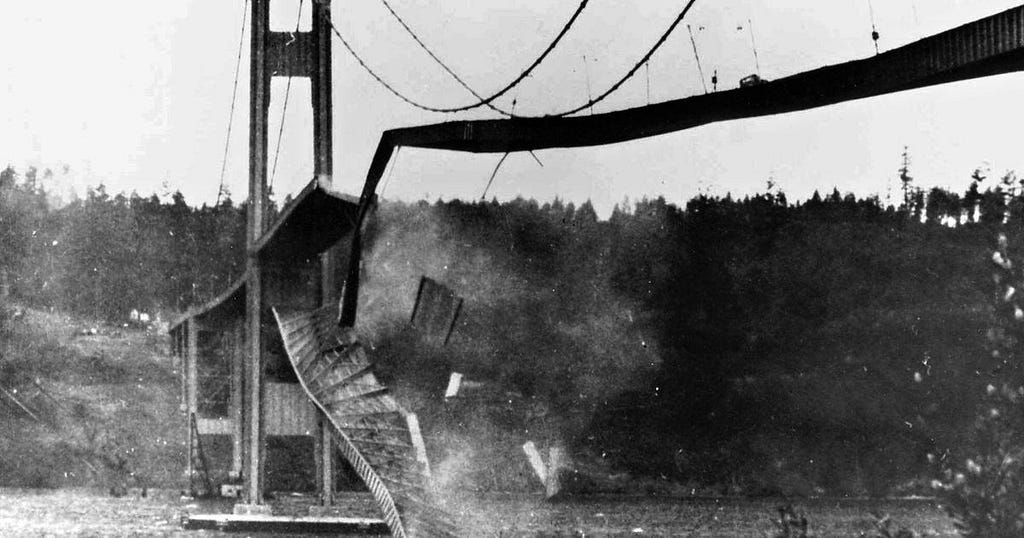 b/w photo of a suspension bridge collapsing
