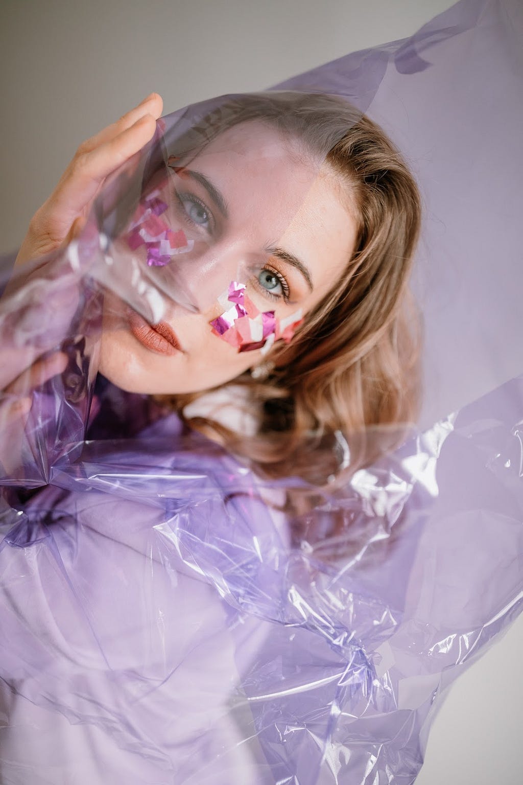 Alex Lilly poses with whimsical fabric and colorful makeup.