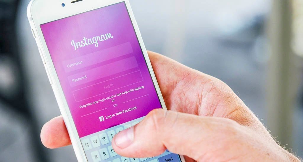 Entrepreneur creating Instagram account for his business on cell phone