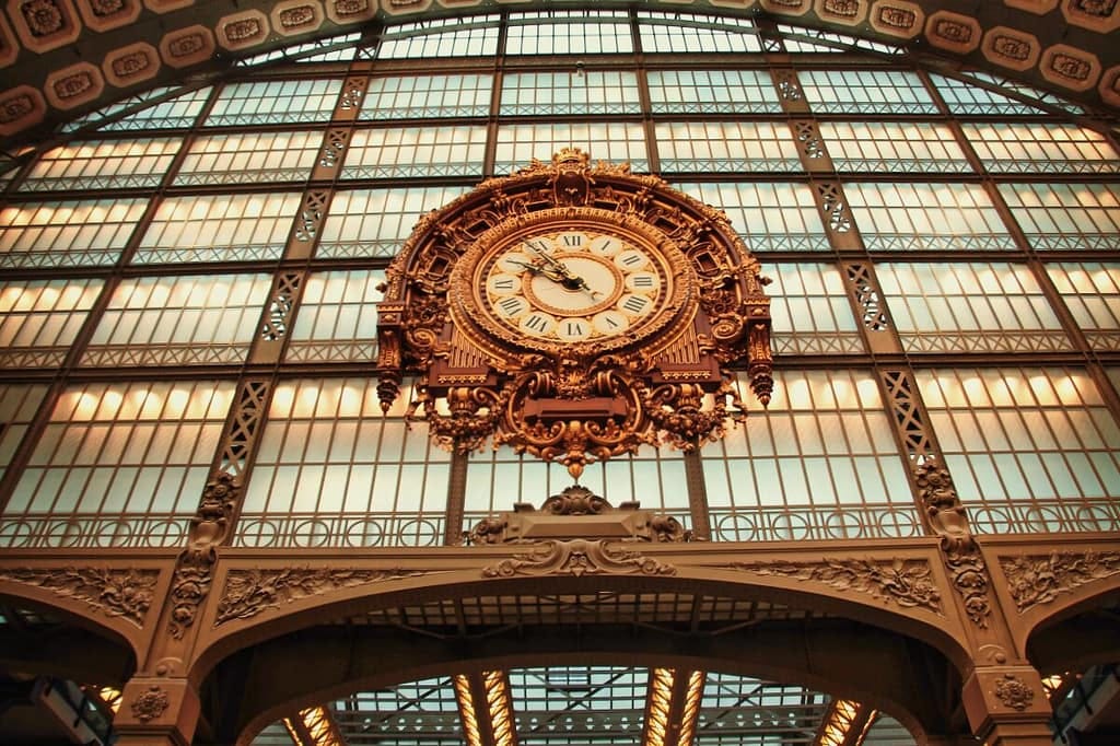 A large ornate clock hanging from the ceiling of a building.