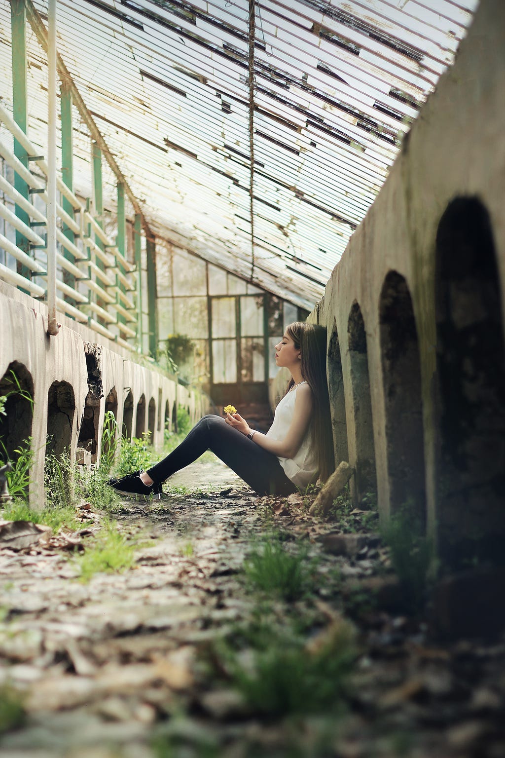 Girl sitting on the ground between buildings
