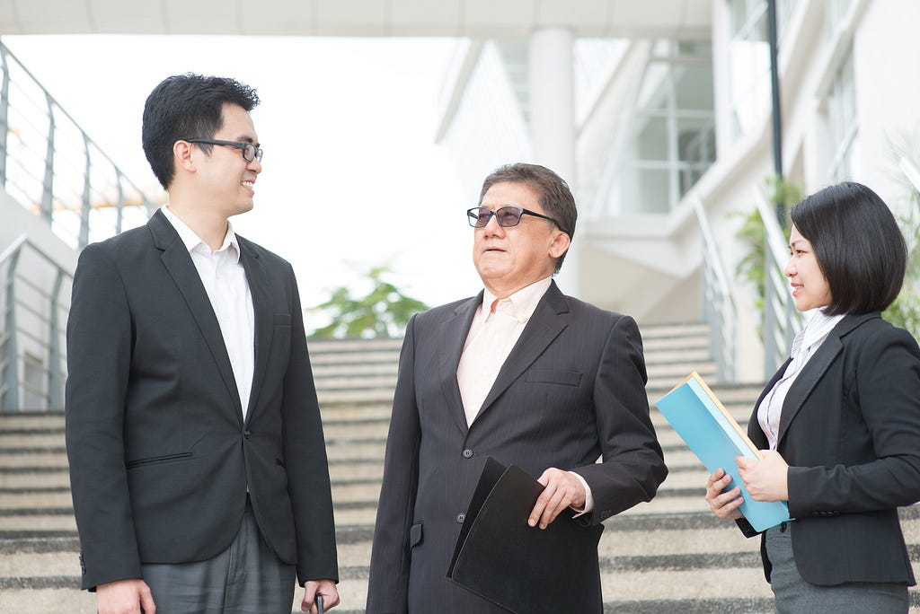 Asian business team having a discussion outside their office.