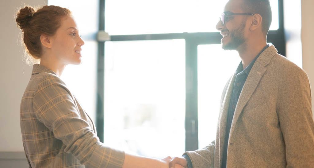 Hiring manager shaking hand with employee after successful interview