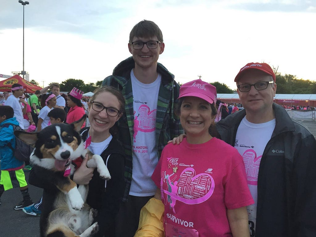 Husband and wife at an outdoor running race with corgi dog and parents