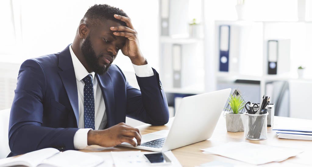 Frustrated entrepreneur working with laptop in office making a mistake