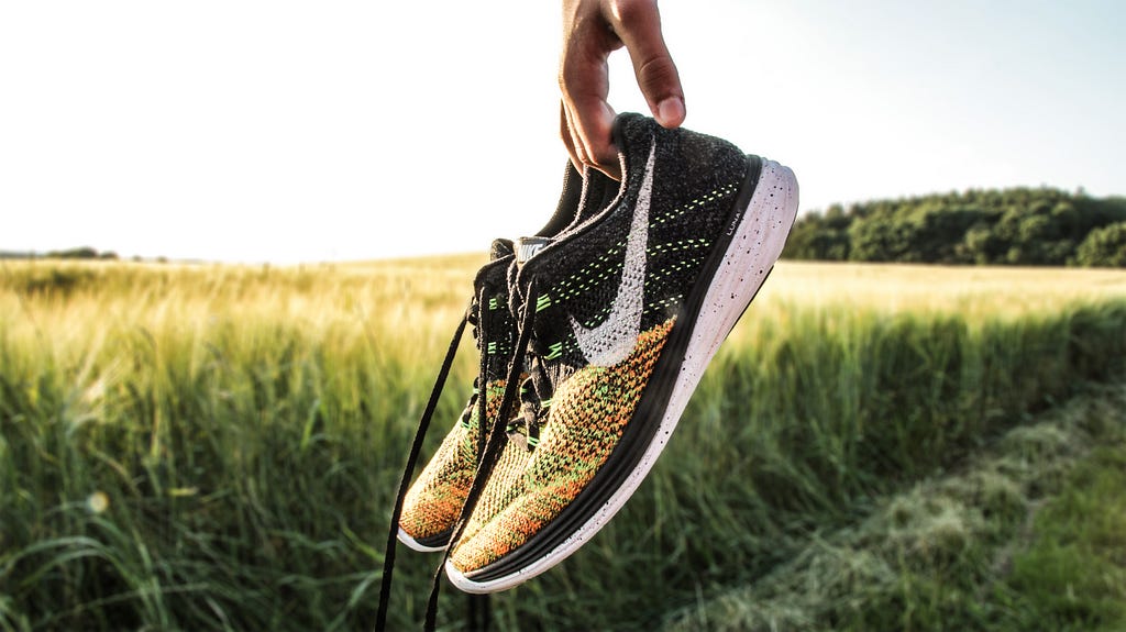 A picture of Nike Running shoes being held up.