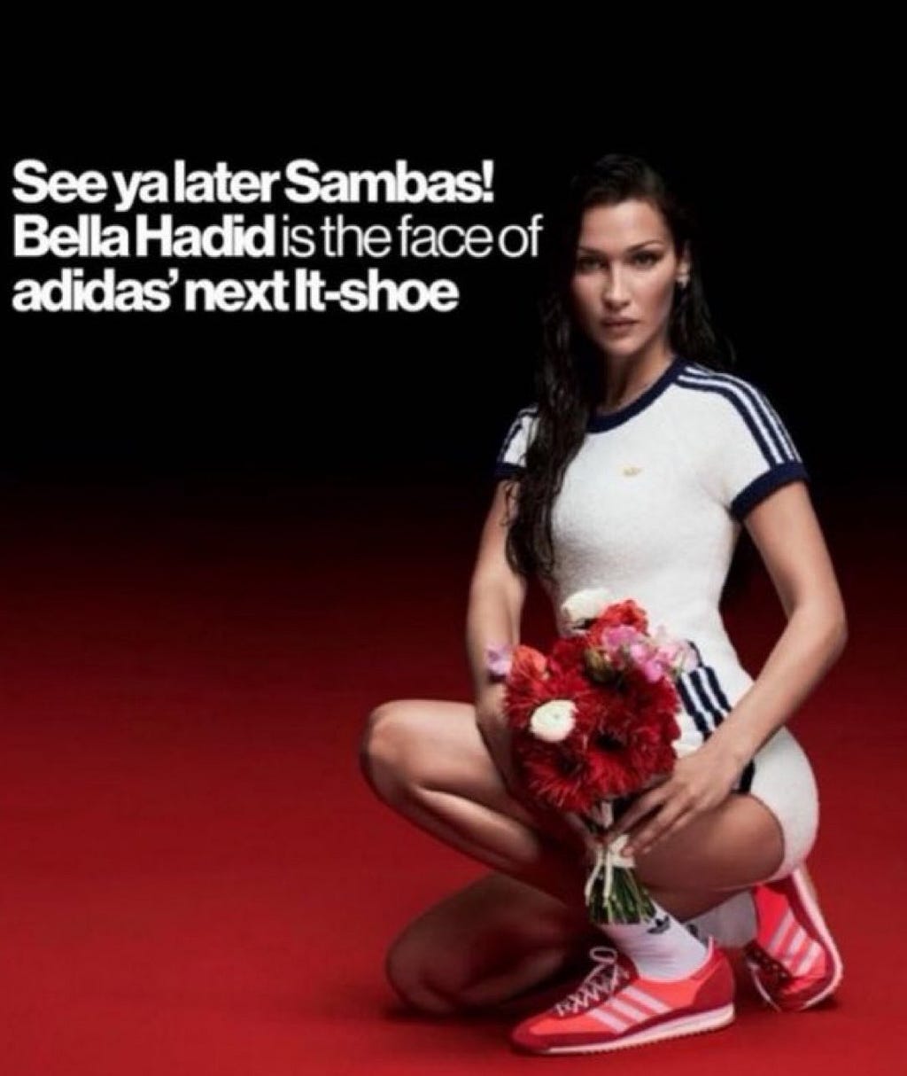 Model promoting Adidas' new It-shoe, holding a bouquet of flowers, wearing a white and blue outfit with red Adidas sneakers.