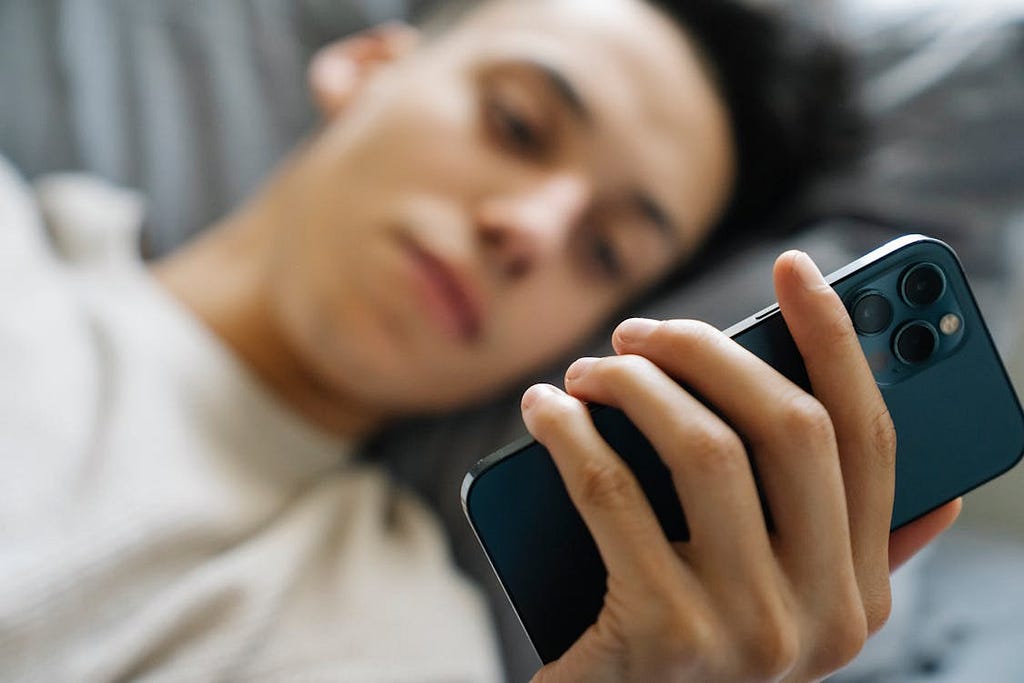 Man using his phone in bed