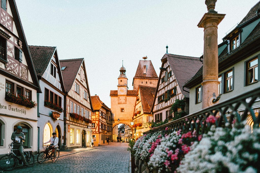 A town center with flowers and people biking