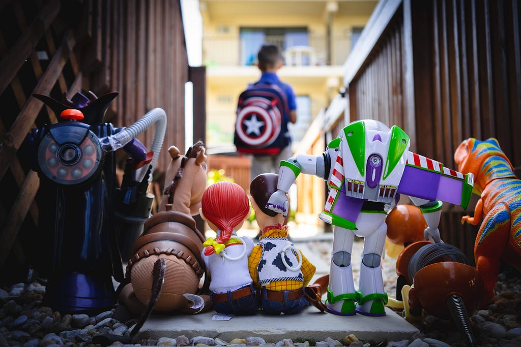 Toy Story characters; out of focus: a boy carrying a Captain America backpack.