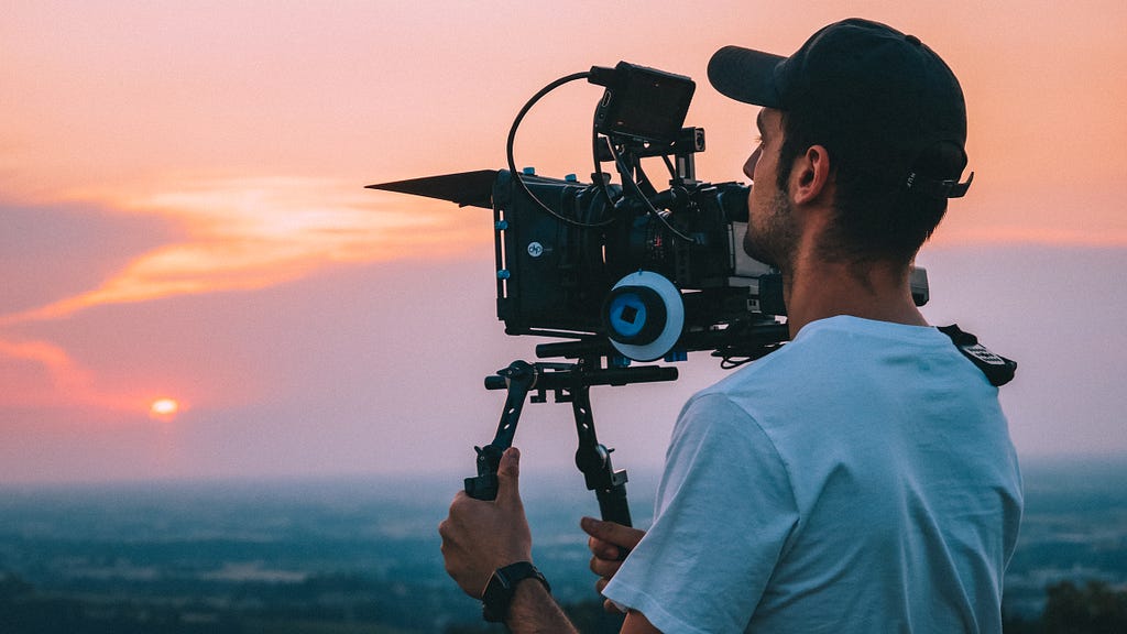 Filmmaker holding cinema camera during a sunset