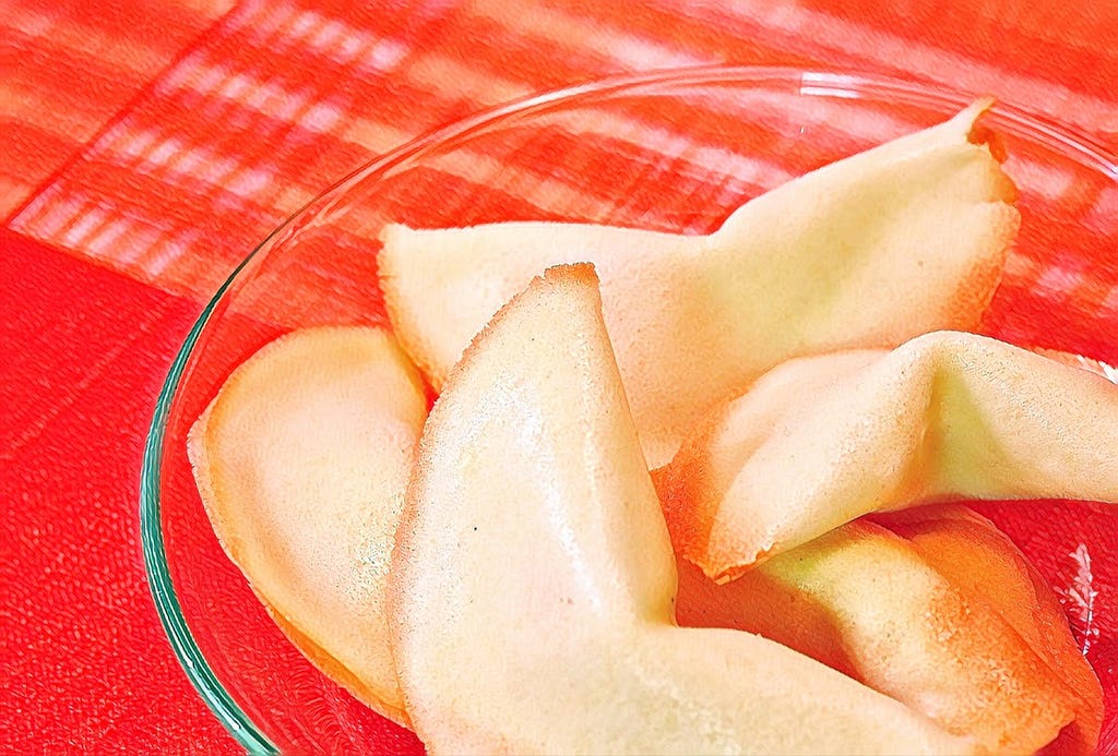 A bowl of fortune cookies on a red table cloth