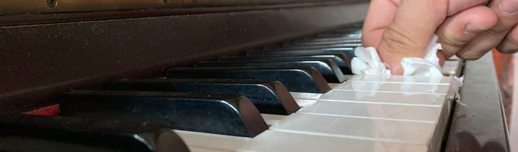 person wiping piano keys