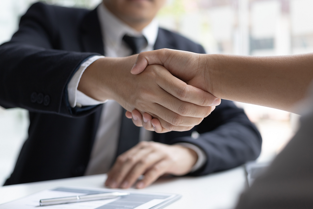 The image resembles a job seeker shaking hand with a potential HR manager. It could be translated that this candidate passed the interview and land a job in a digital marketing field.