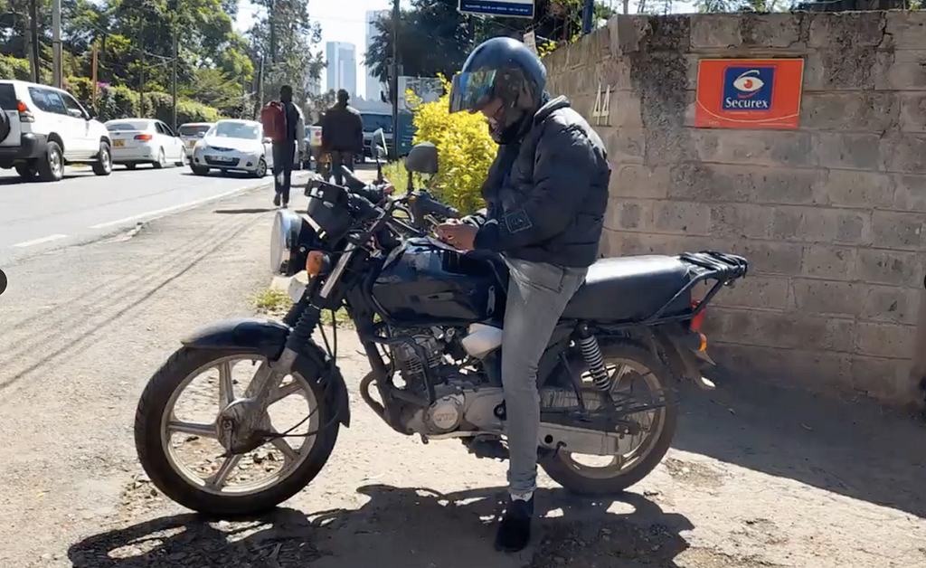 A female motorcycle rider looking at her phone